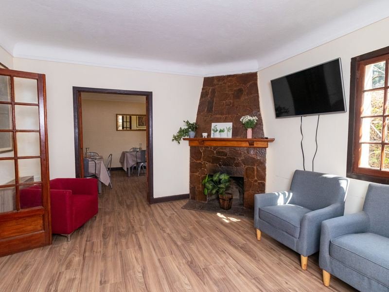 Sala de estar con chimenea, sillones y televisor.