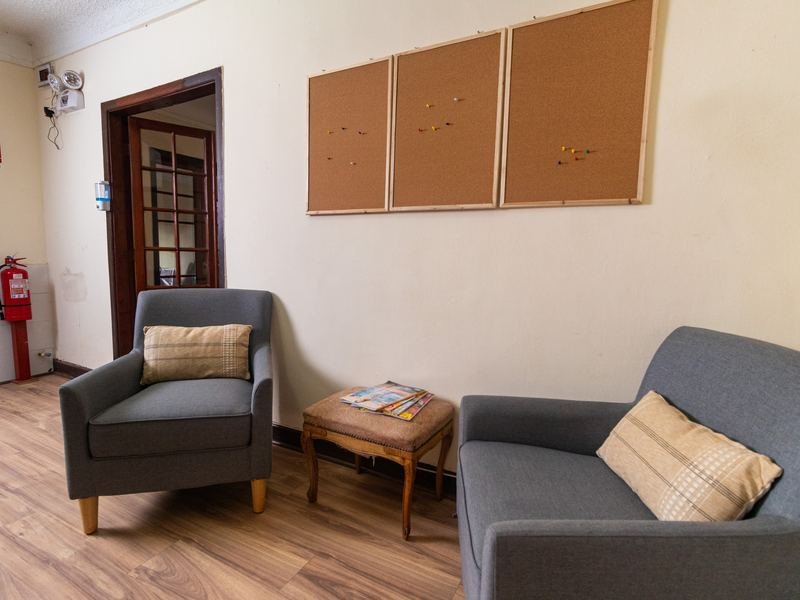 Sala de espera con sofá, cojines y diario mural.