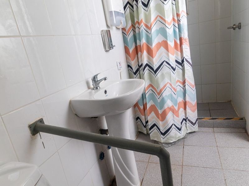 Ducha con barra de apoyo y cortina.