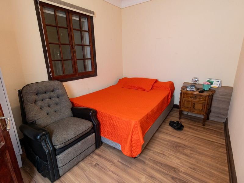 Habitación individual con sillón reclinable junto a la cama.